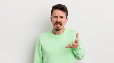 Genç yakışıklı adam sinirli, sinirli ve sinirli görünüyor.