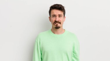 Şaşkın ve kafası karışmış genç yakışıklı bir adam.