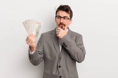 Genç yakışıklı düşünen, kuşkulu ve kafası karışık bir adam. İş adamı ve banknotlar