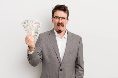 Genç ve yakışıklı bir adam tiksinmiş ve sinirlenmiş hissediyor ve dilini dışarı çıkarıyor. İş adamı ve banknotlar