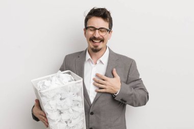 Genç yakışıklı bir adam komik bir şakaya yüksek sesle gülüyor. Kağıt toplar sepeti konsepti