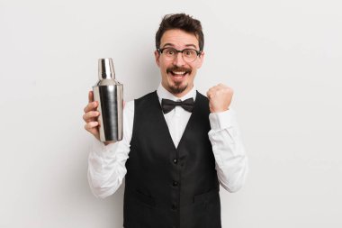 Genç yakışıklı adam şok olmuş hissediyor, gülüyor ve başarıyı kutluyor. Kokteyl barmeni