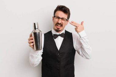 Genç yakışıklı adam mutsuz ve stresli görünüyor, intihar jesti silah işareti yapıyor. Kokteyl barmeni