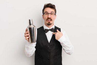 Şok olmuş ve ağzı açık, kendini işaret eden genç ve yakışıklı bir adam. Kokteyl barmeni