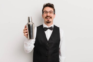 Genç yakışıklı adam mutlu ve hoş bir şekilde şaşırmış görünüyor. Kokteyl barmeni
