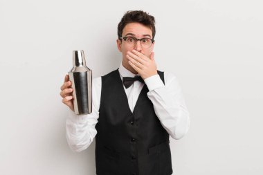 Genç ve yakışıklı bir adam elleri ile ağzını kapatıyor ve şok geçiriyor. Kokteyl barmeni