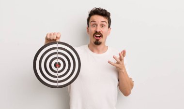 Genç yakışıklı adam, inanılmaz bir sürprizle şaşkına dönmüş ve hayrete düşmüştü. dart hedef konsepti