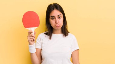 Genç İspanyol kadın üzgün ve mızmızlanıyor. Mutsuz bir bakışı var ve ağlıyor. ping pong konsepti