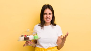 Genç İspanyol kadın umutsuz, hayal kırıklığına uğramış ve stresli görünüyor. Ev yapımı kek konsepti