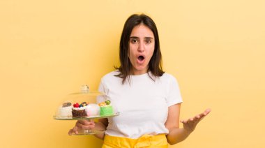 Genç İspanyol kadın şok olmuş ve şaşırmış hissediyor. Ev yapımı kek konsepti