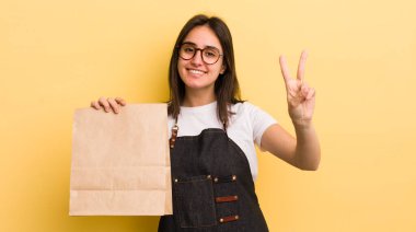 Genç İspanyol kadın gülümsüyor ve mutlu görünüyor, zafer ya da barış işareti yapıyor. Fast food konsepti