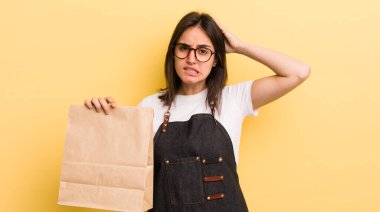 Genç İspanyol kadın stresli, endişeli ya da korkmuş hissediyor, elleri başının üstünde. Fast food konsepti