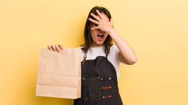 Genç İspanyol bir kadın şok olmuş, korkmuş ya da korkmuş görünüyor. Yüzü elle kapatılmış. Fast food konsepti