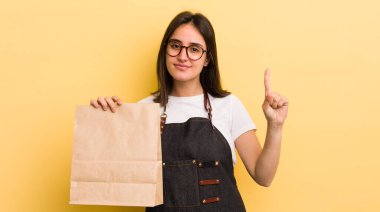 Genç İspanyol kadın gülümsüyor ve arkadaş canlısı görünüyor, bir numarayı gösteriyor. Fast food konsepti