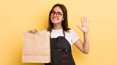 Genç İspanyol kadın gülümsüyor ve arkadaş canlısı görünüyor, beş numarayı gösteriyor. Fast food konsepti