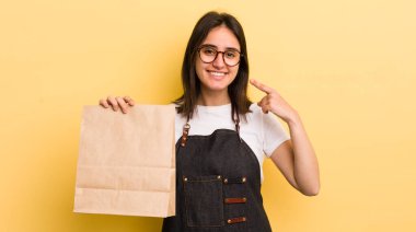 Genç İspanyol kadın kendine güvenerek gülümsüyor ve kendi gülüşünü gösteriyor. Fast food konsepti