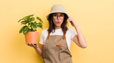 Genç İspanyol kadın şaşırmış görünüyor, yeni bir düşünce, fikir ya da konsept keşfediyor. Bahçıvan ve bitki konsepti