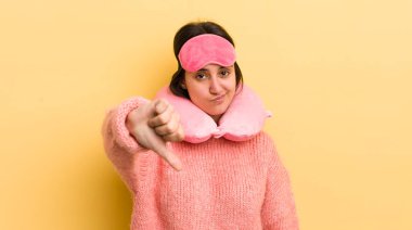 Latin kökenli genç bir kadın kızmış, baş parmağını kaldırmış. uçuş yolcu kavramı