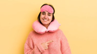 Genç İspanyol kadın neşeyle gülümsüyor, mutlu hissediyor ve bir tarafı işaret ediyor. uçuş yolcu kavramı