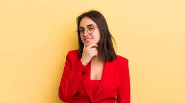 Genç İspanyol kadın mutlu ve kendinden emin bir ifadeyle gülümsüyor. Elleri çenesinde. iş kavramı