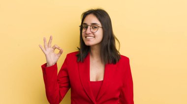 Genç İspanyol kadın kendini mutlu hissediyor, iyi bir jestle onaylıyor. iş kavramı