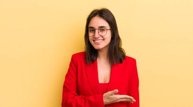 Genç İspanyol kadın neşeyle gülümsüyor, mutlu hissediyor ve bir konsept gösteriyor. iş kavramı