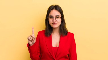 Genç İspanyol kadın gülümsüyor ve arkadaş canlısı görünüyor, bir numarayı gösteriyor. iş kavramı