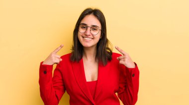 Genç İspanyol kadın kendine güvenerek gülümsüyor ve kendi gülüşünü gösteriyor. iş kavramı