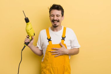 Komik bir şakaya yüksek sesle gülmek. Matkap konsepti olan tamirci.