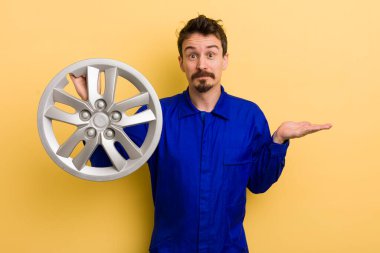 Adam şaşkın, şaşkın ve şüpheci hissediyor. araba tamircisi konsepti