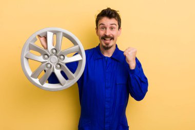 Adam şok olmuş hissediyor, gülüyor ve başarıyı kutluyor. araba tamircisi konsepti
