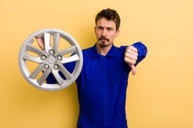 Adam kendini kötü hissediyor, baş parmağını kaldırıyor. araba tamircisi konsepti