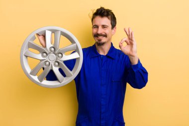 Adam kendini mutlu hissediyor, iyi bir jestle onay veriyor. araba tamircisi konsepti