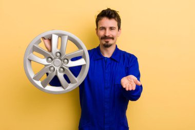 Adam mutlu bir şekilde gülümsüyor ve bir konsept sunuyor. araba tamircisi konsepti