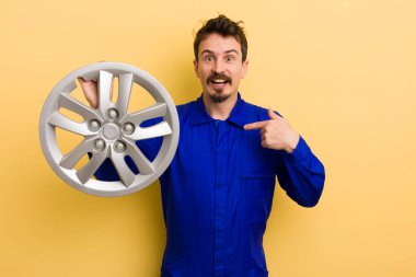 Adam mutlu hissediyor ve heyecanla kendini işaret ediyor. araba tamircisi konsepti