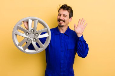 Mutlu bir şekilde gülümseyen, el sallayan, seni selamlayan bir adam. araba tamircisi konsepti