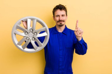 Gülümseyen ve arkadaş canlısı görünen bir adam, bir numarayı gösteriyor. araba tamircisi konsepti