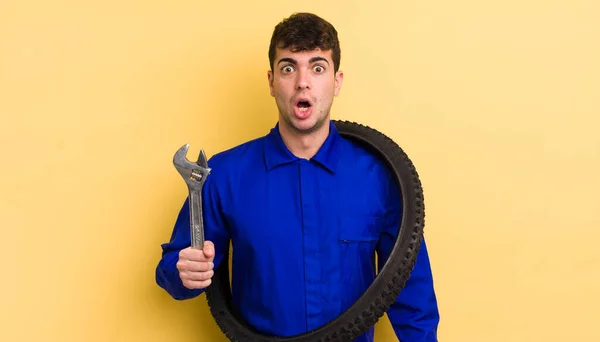 Joven Hombre Guapo Buscando Muy Sorprendido Sorprendido Concepto Reparador Bicicletas — Foto de Stock