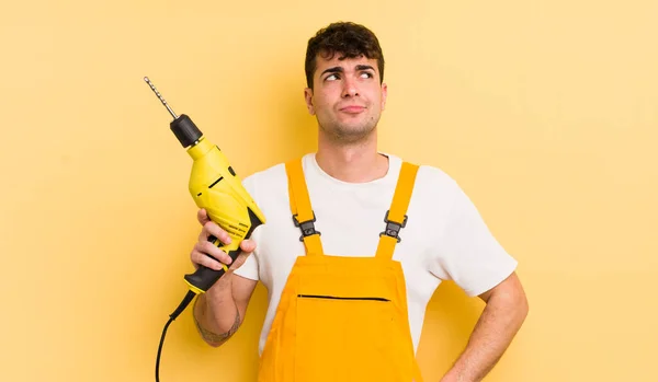 Young Handsome Man Shrugging Feeling Confused Uncertain Handyman Drill Concept — Stock Photo, Image