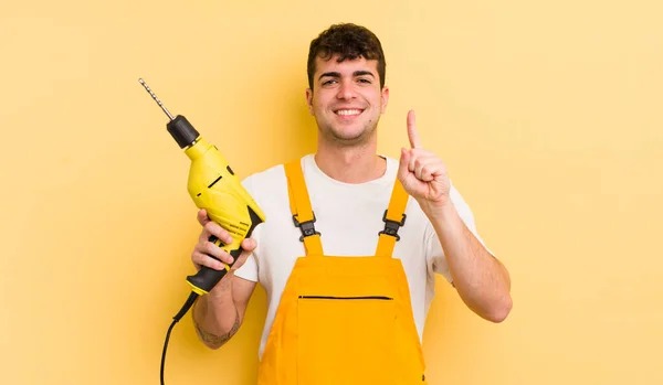 Jovem Bonito Homem Sorrindo Olhando Amigável Mostrando Número Handyman Conceito — Fotografia de Stock