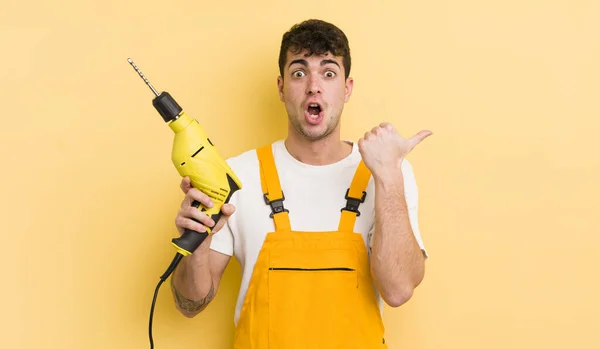 Jovem Homem Bonito Olhando Espantado Descrença Handyman Conceito Broca — Fotografia de Stock