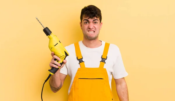 Jovem Homem Bonito Olhar Confuso Confuso Handyman Conceito Broca — Fotografia de Stock