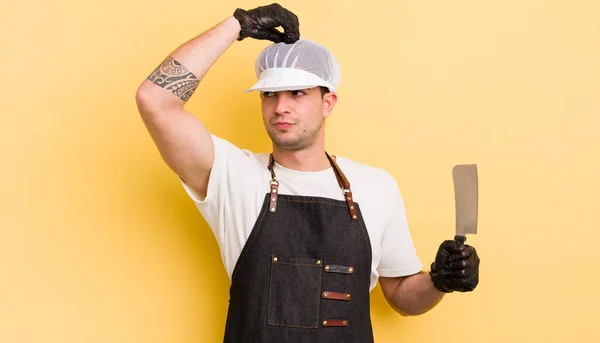 Jovem Homem Bonito Sentindo Intrigado Confuso Coçando Cabeça Conceito Açougueiro — Fotografia de Stock