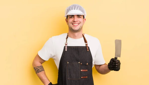 若いハンサムな男が喜んで笑顔で手を腰と自信を持って 肉屋のコンセプト — ストック写真