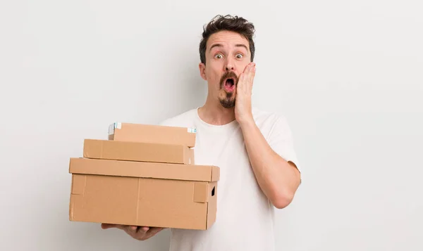 Jovem Homem Bonito Sentindo Chocado Assustado Conceito Caixas Transporte — Fotografia de Stock