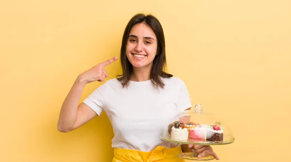 若いヒスパニック系の女性が自信を持って笑顔を指す 家で作るケーキのコンセプト — ストック写真