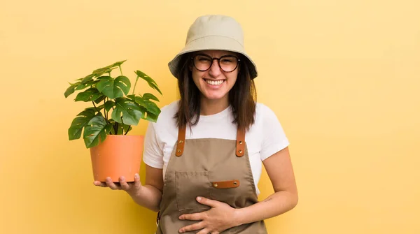若いヒスパニック系の女性が陽気な冗談で大声で笑いました 庭師と植物のコンセプト — ストック写真