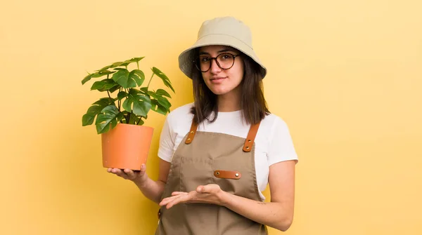 若いヒスパニック系の女性は陽気に笑顔で 幸せを感じ 概念を示す 庭師と植物のコンセプト — ストック写真