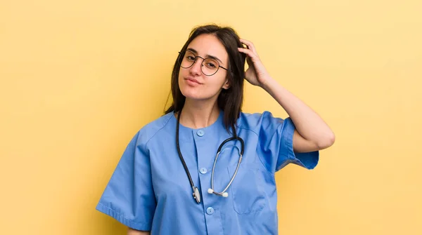 若いヒスパニック系の女性は楽しそうに笑ったり空想したり疑問に思っています 看護師の概念 — ストック写真