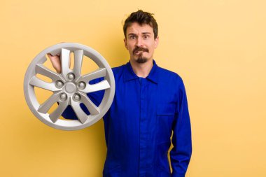 Adam şaşkın ve şaşkın görünüyor. araba tamircisi konsepti